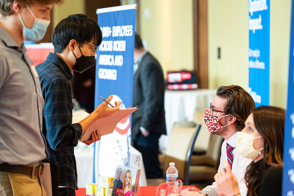 Representatives from Uline, a shipping and business supply company based in Pleasant Prairie, Wisconsin, talk with students during a School of Computer, Data and Information Sciences (CDIS) career fair held in Varsity Hall inside Union South at the University of Wisconsin–Madison on Feb. 15, 2022.