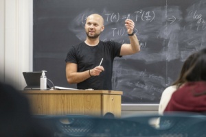 Albarghouthi explaining complex mathematical equations on a chalkboard in a classroom setting.