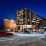 Cars pass by Morgridge Hall on the UW–Madison campus at night.